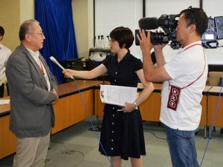 NHKからの取材を受ける、鈴木常任理事。